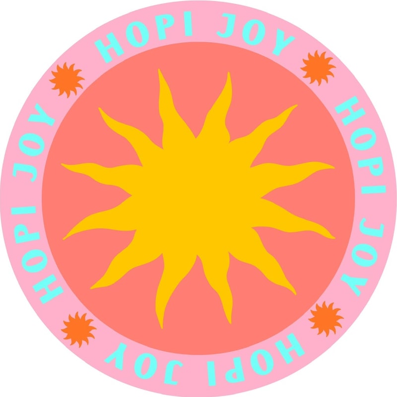 Hopi Joy badge: a golden sun in a pink and coral circle with the words Hopi Joy around it
